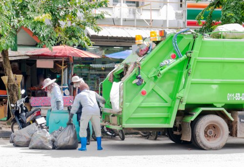 Operatives wearing PPE and arranging a skip on a residential street